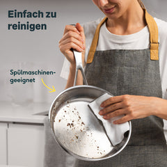 Edelstahlpfanne unbeschichtet wird von Frau mit Schürze ausgewischt, Text: Einfach zu reinigen, Spülmaschinengeeignet.